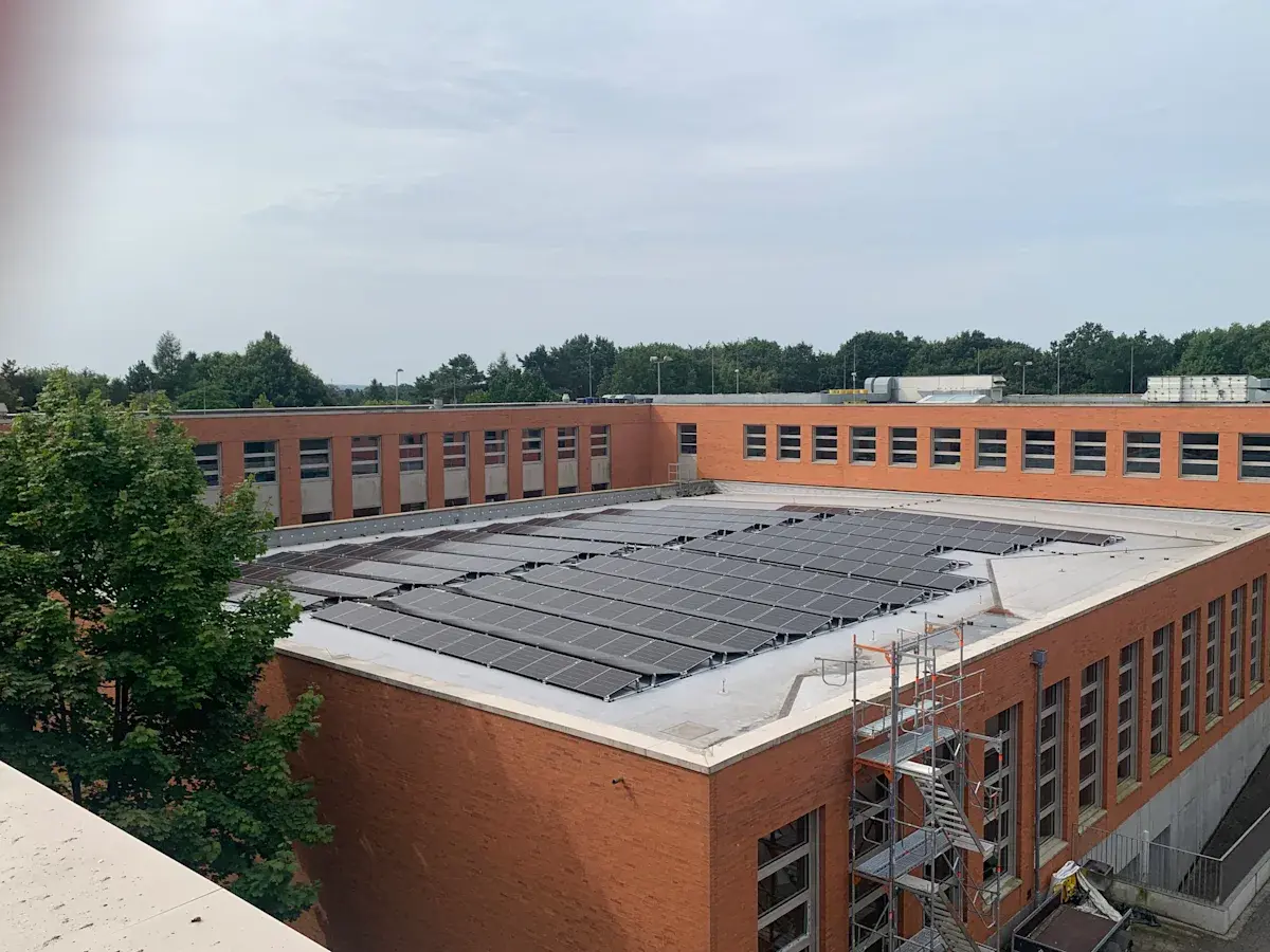 Elevated view of solar panel array installed on the brick school roof