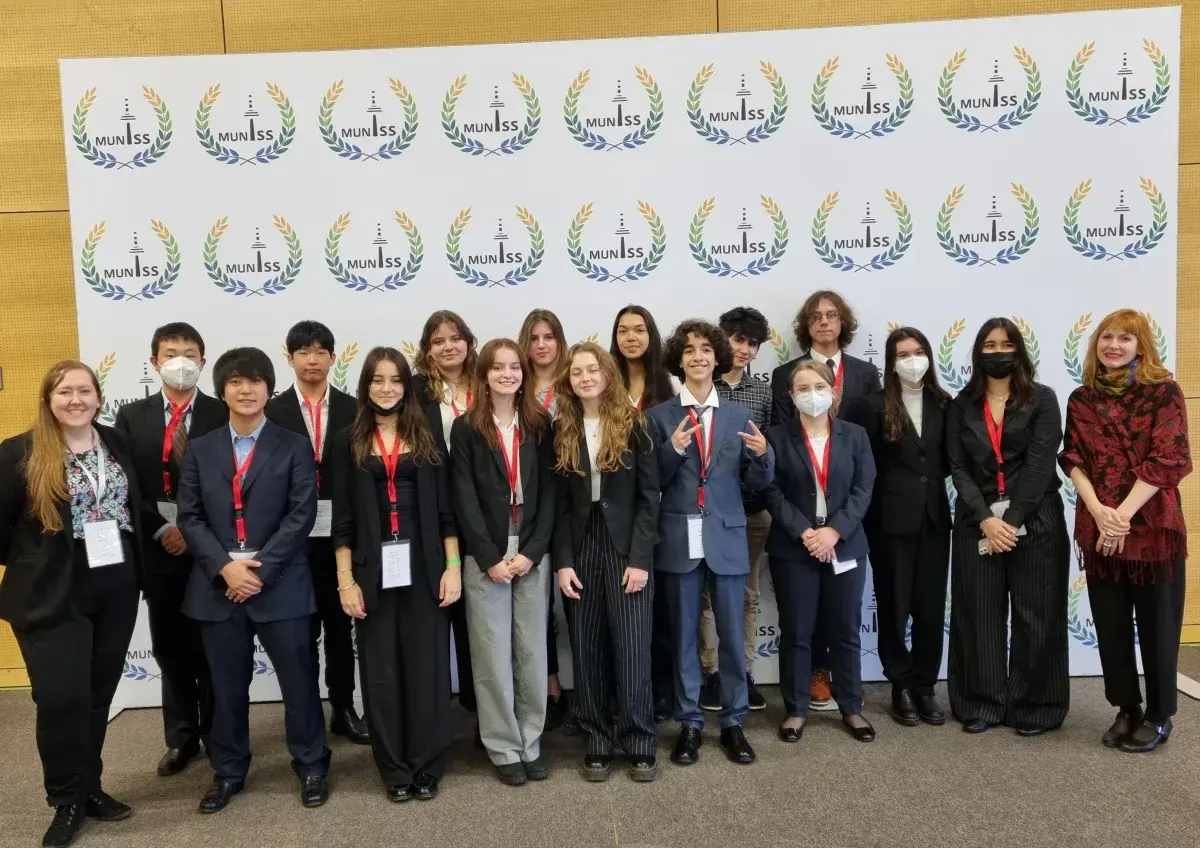Group of students and teachers in formal attire posing together at an academic conference