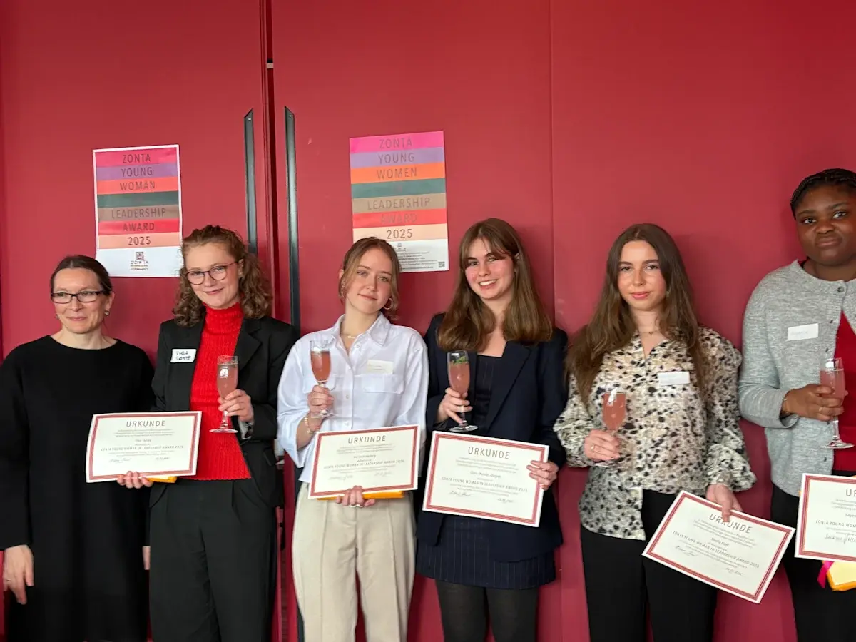 Secondary school students standing together holding award certificates