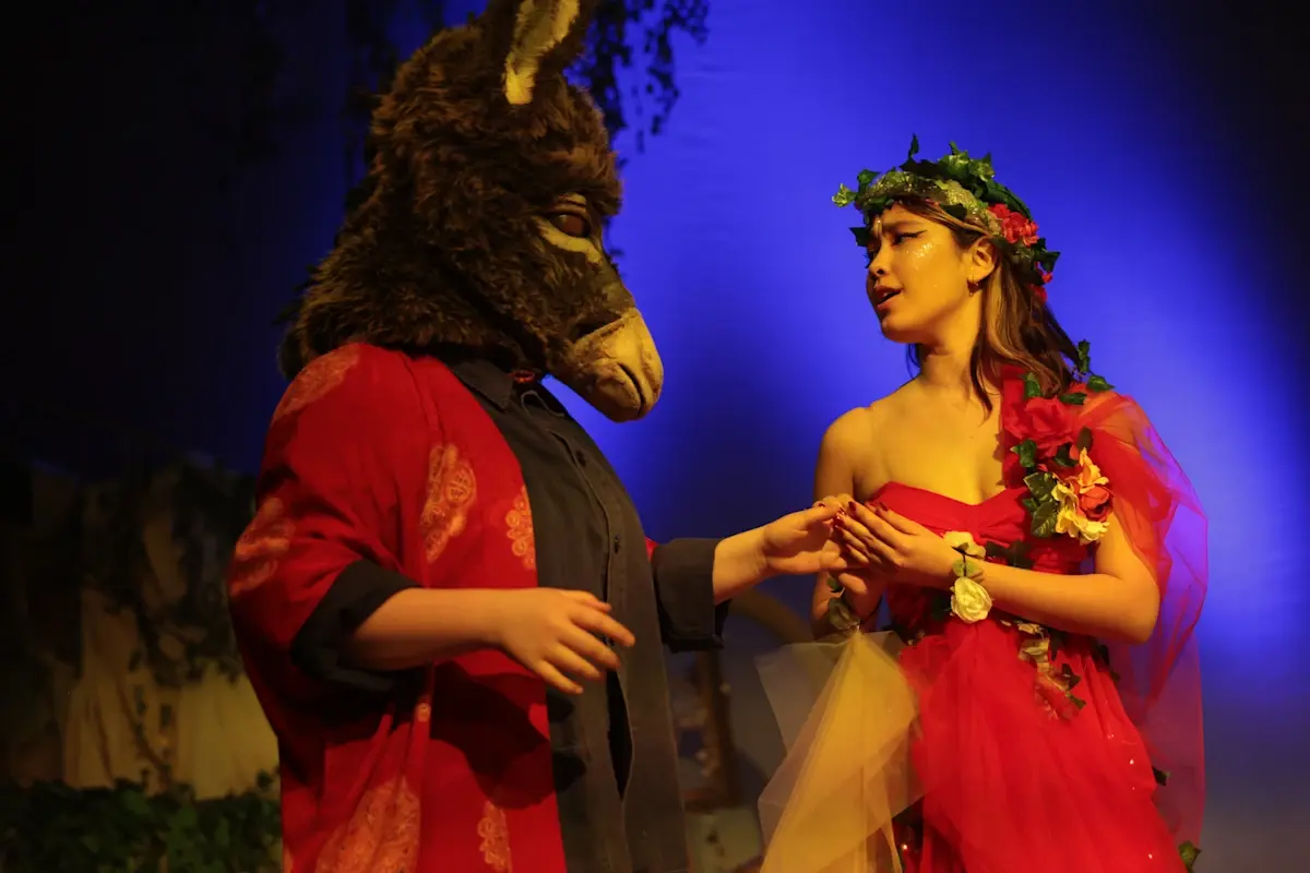 Secondary students performing in costume on stage during a theatrical production